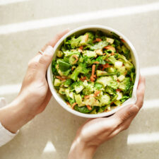 Hands holding a broccoli salad