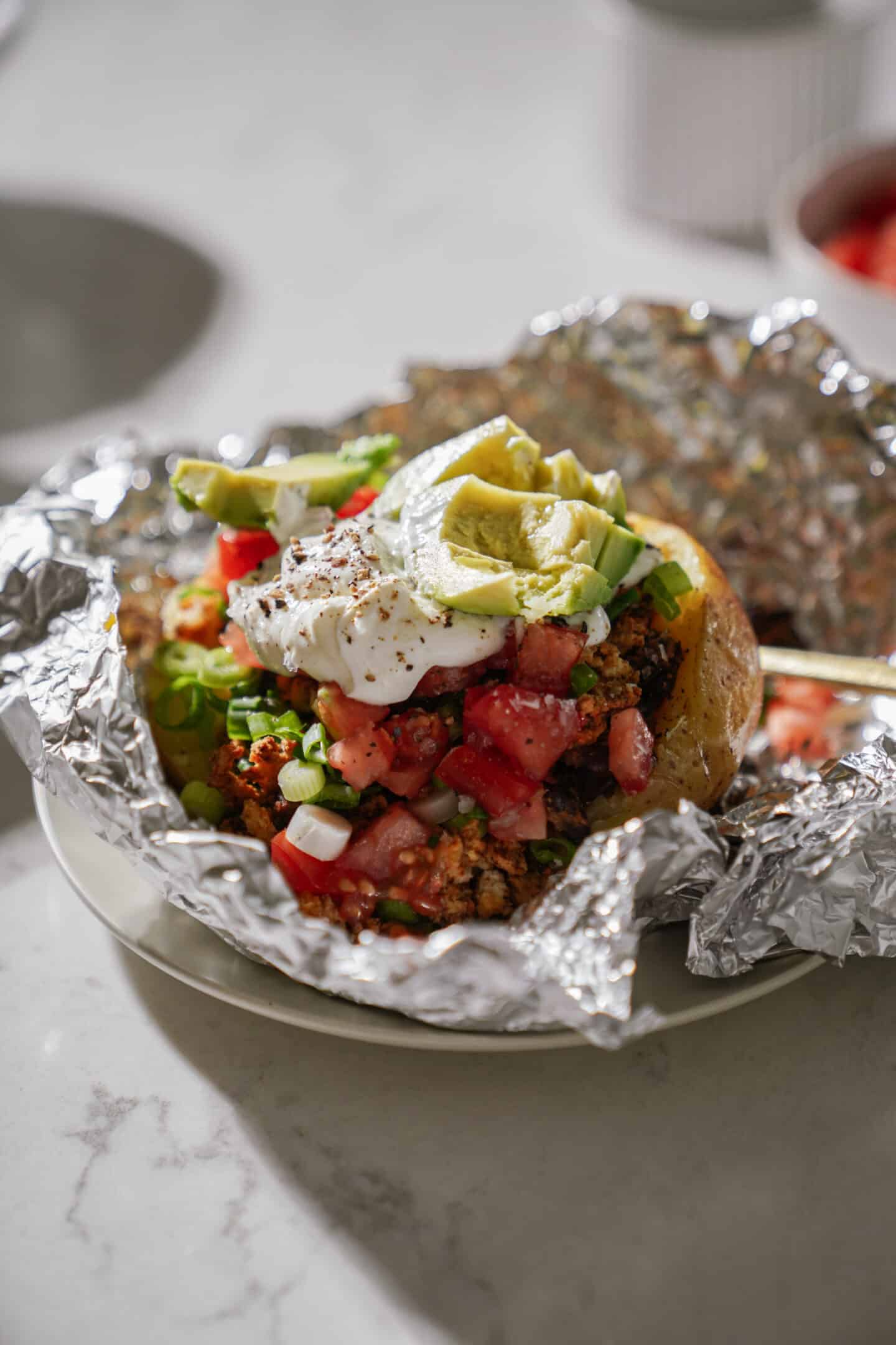 Close-up of a loaded baked potato in foil