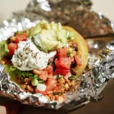 Close-up of a loaded baked potato in tin foil