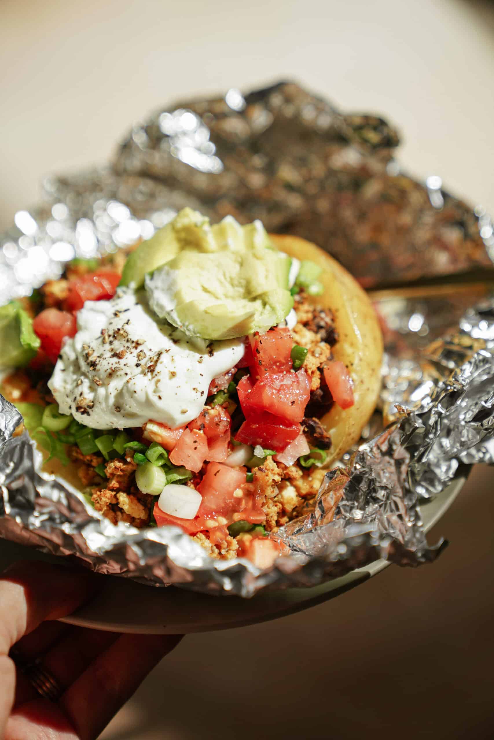 Close-up of a loaded baked potato in tin foil
