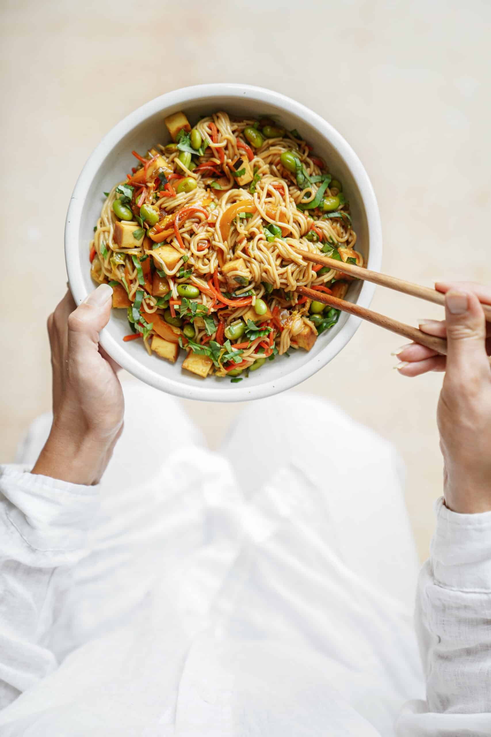 Stir fry veggies with chop sticks scooping them up