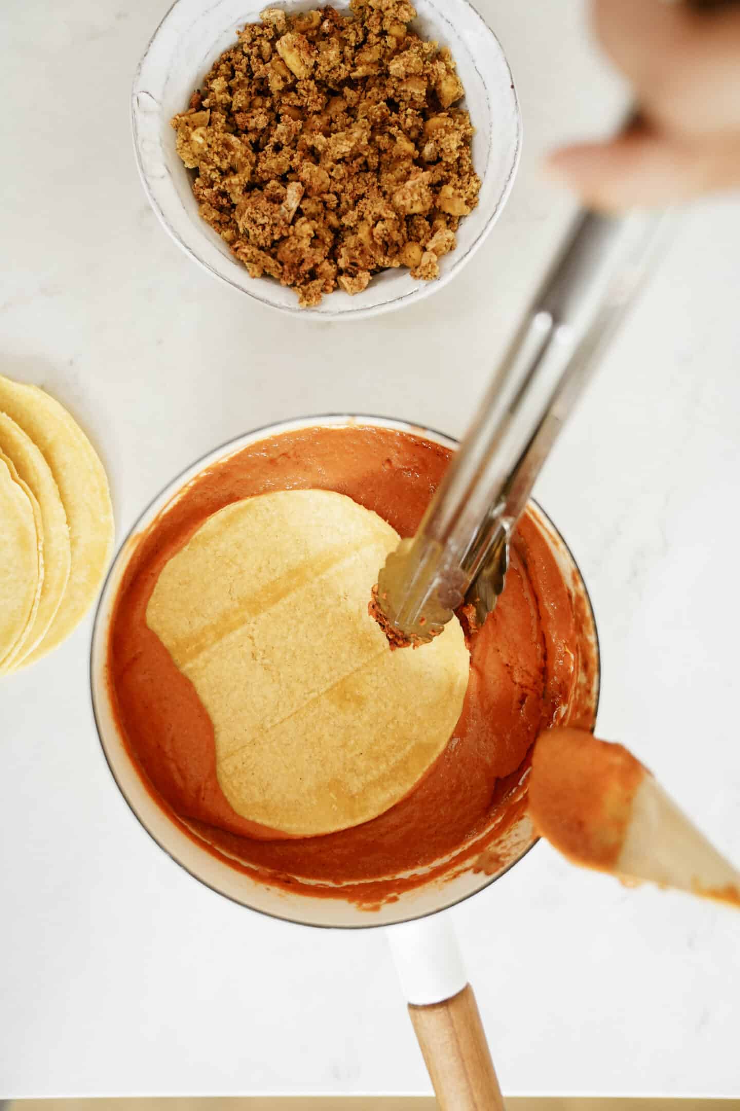 Covering tortillas in sauce