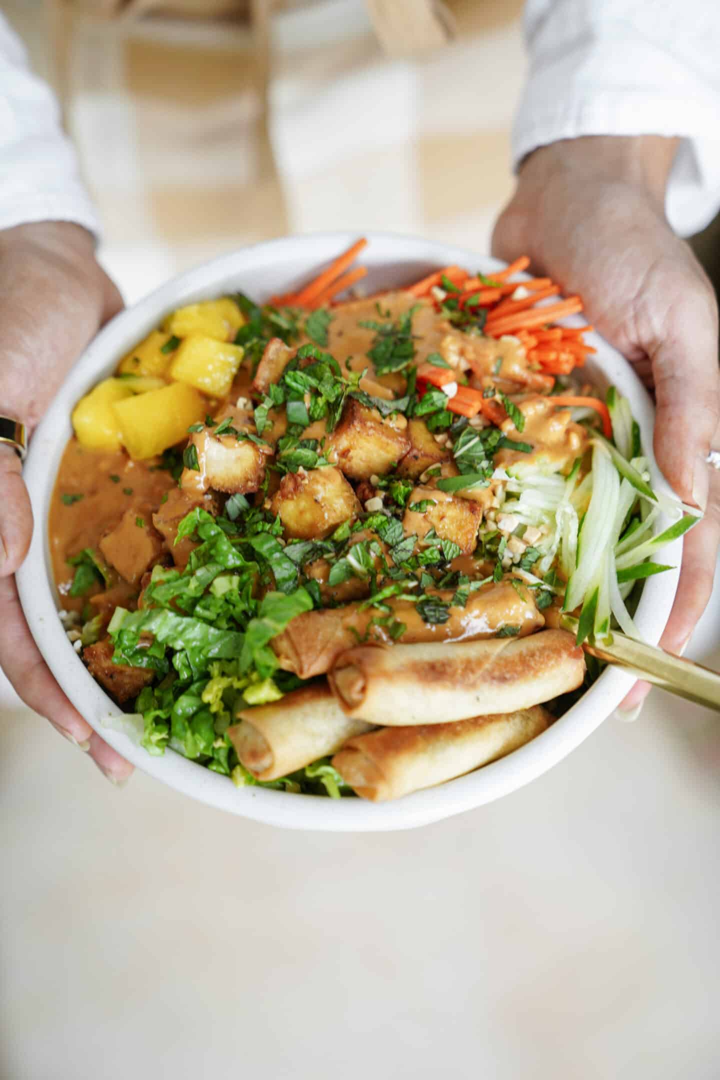 Hands holding a Vermicelli Noodle Bowl in a white bowl