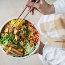 Hands holding chop sticks picking up Vermicelli Noodle Bowl