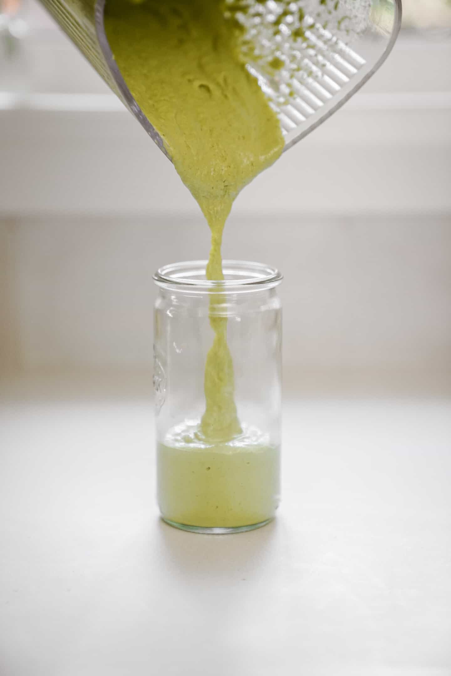 Chimichurri sauce being poured into a jar
