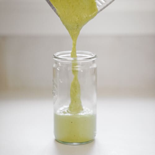 Chimichurri sauce being poured into a jar