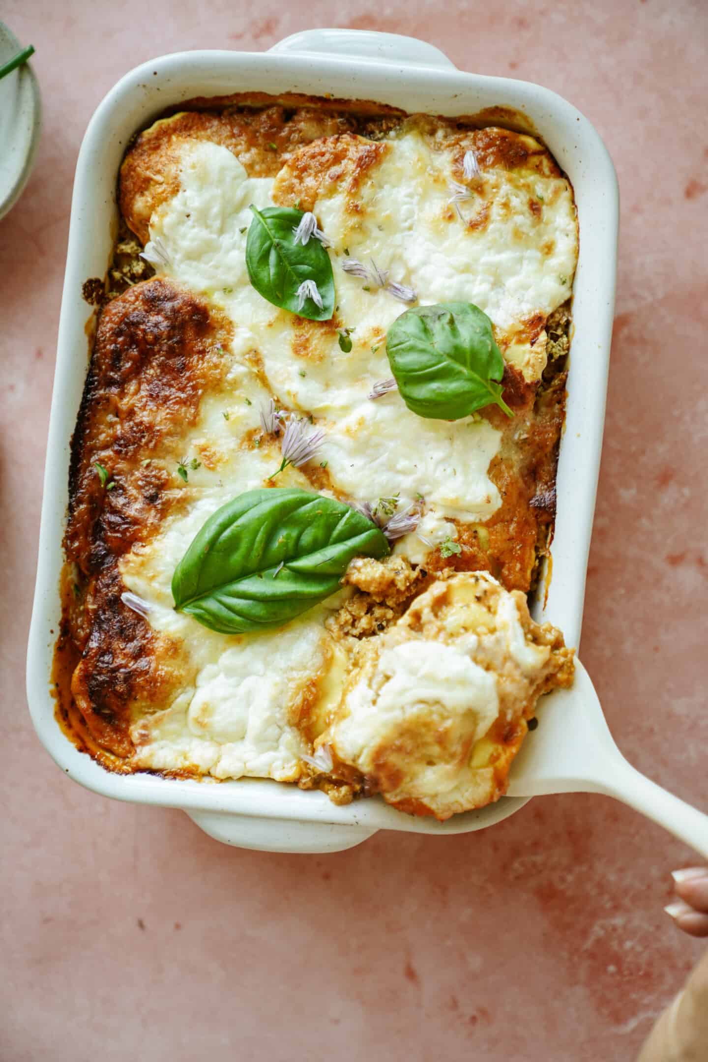 Spatula taking out slice of ravioli casserole