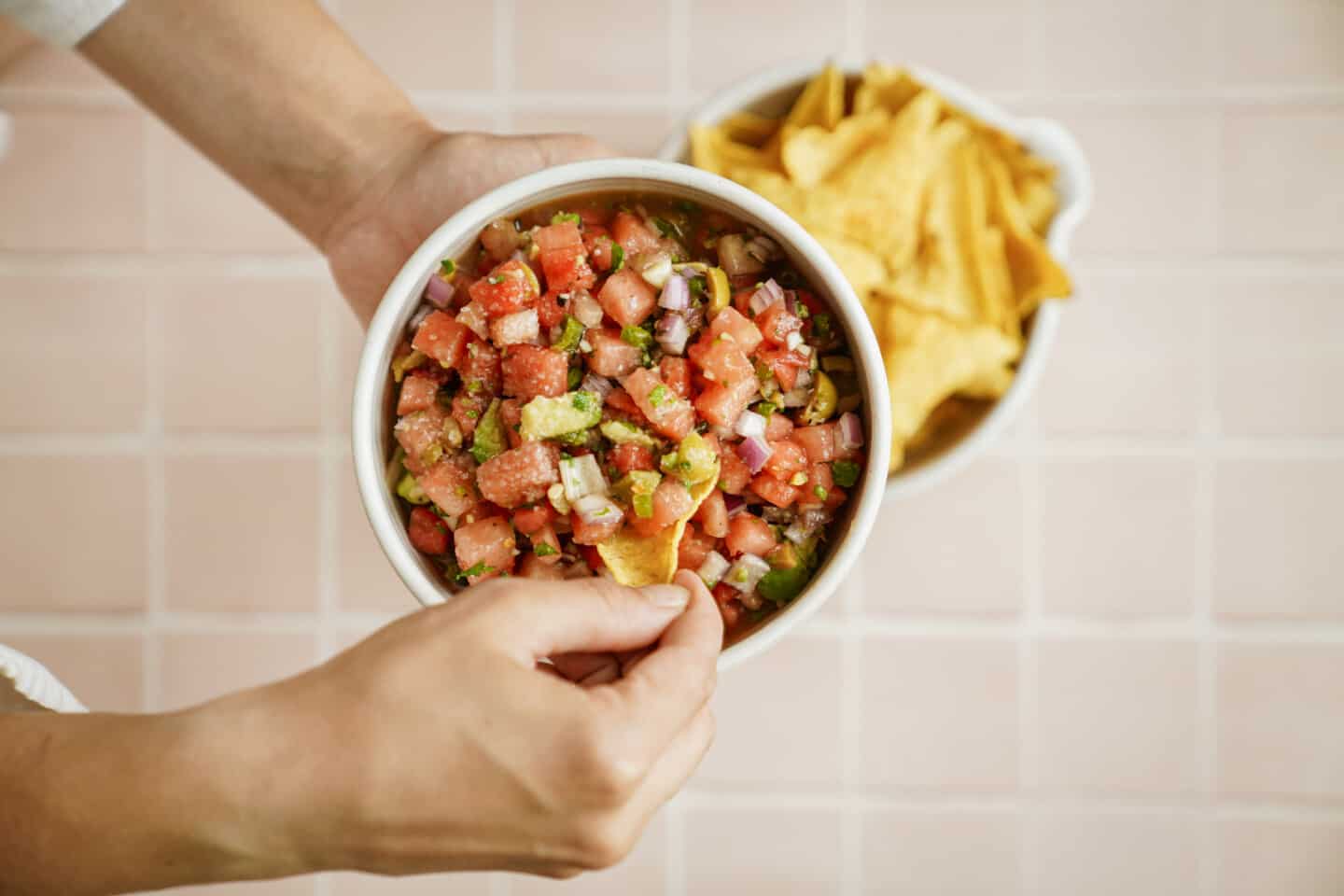 Hand dipping chip into vegan ceviche