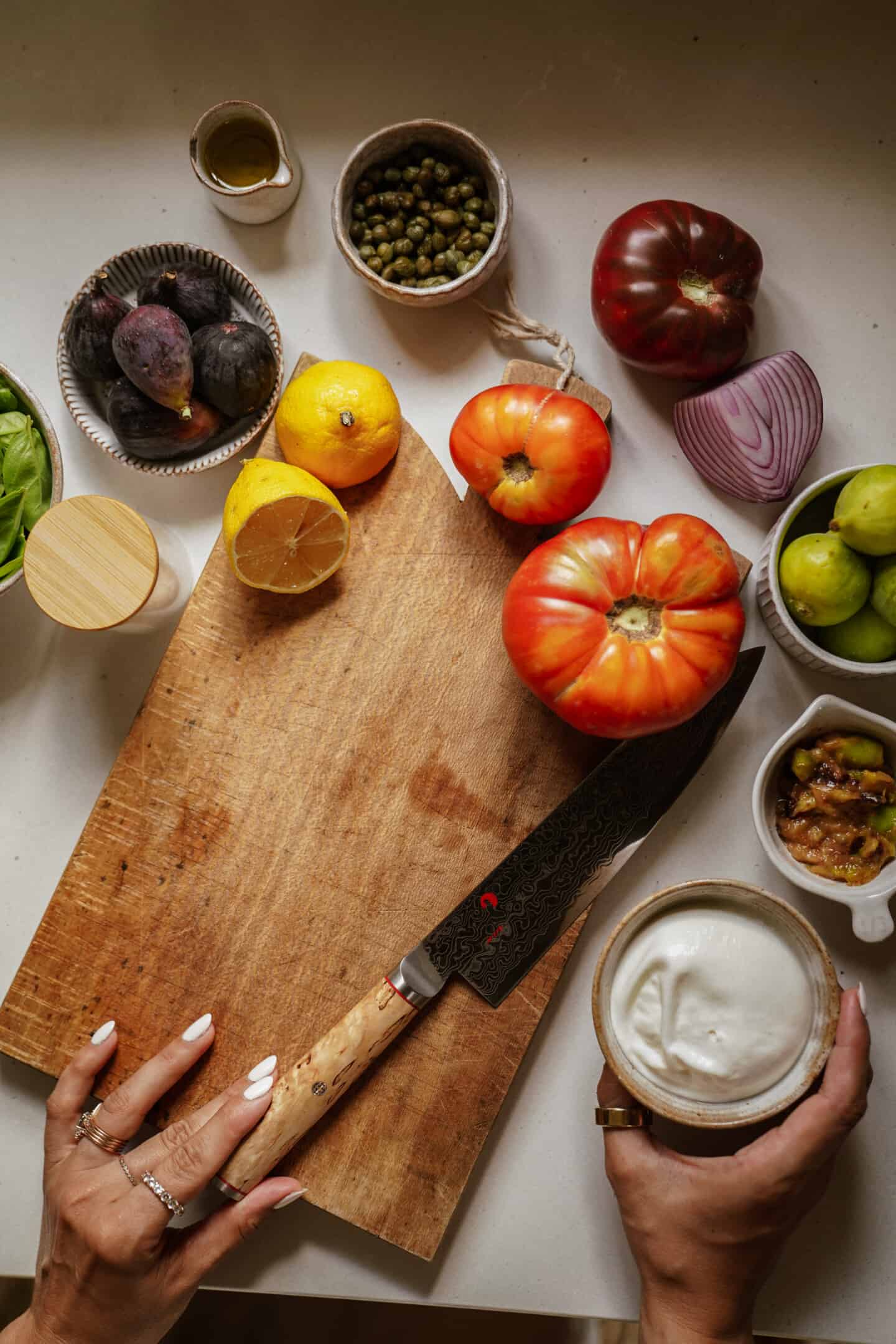 Ingredients laid out with cutting board for burrata salad