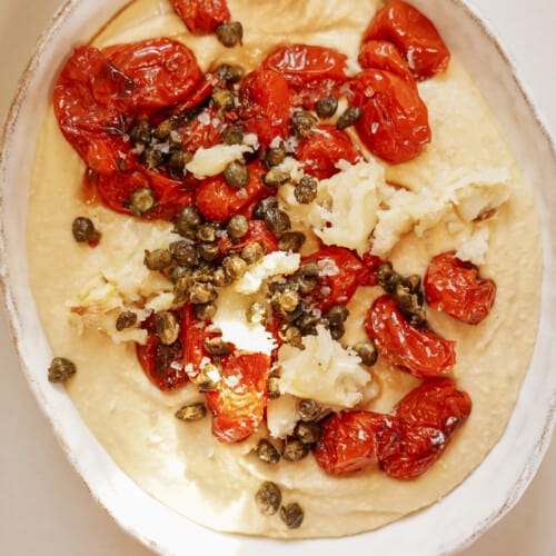 Easy hummus recipe with tomatoes and garlic on top