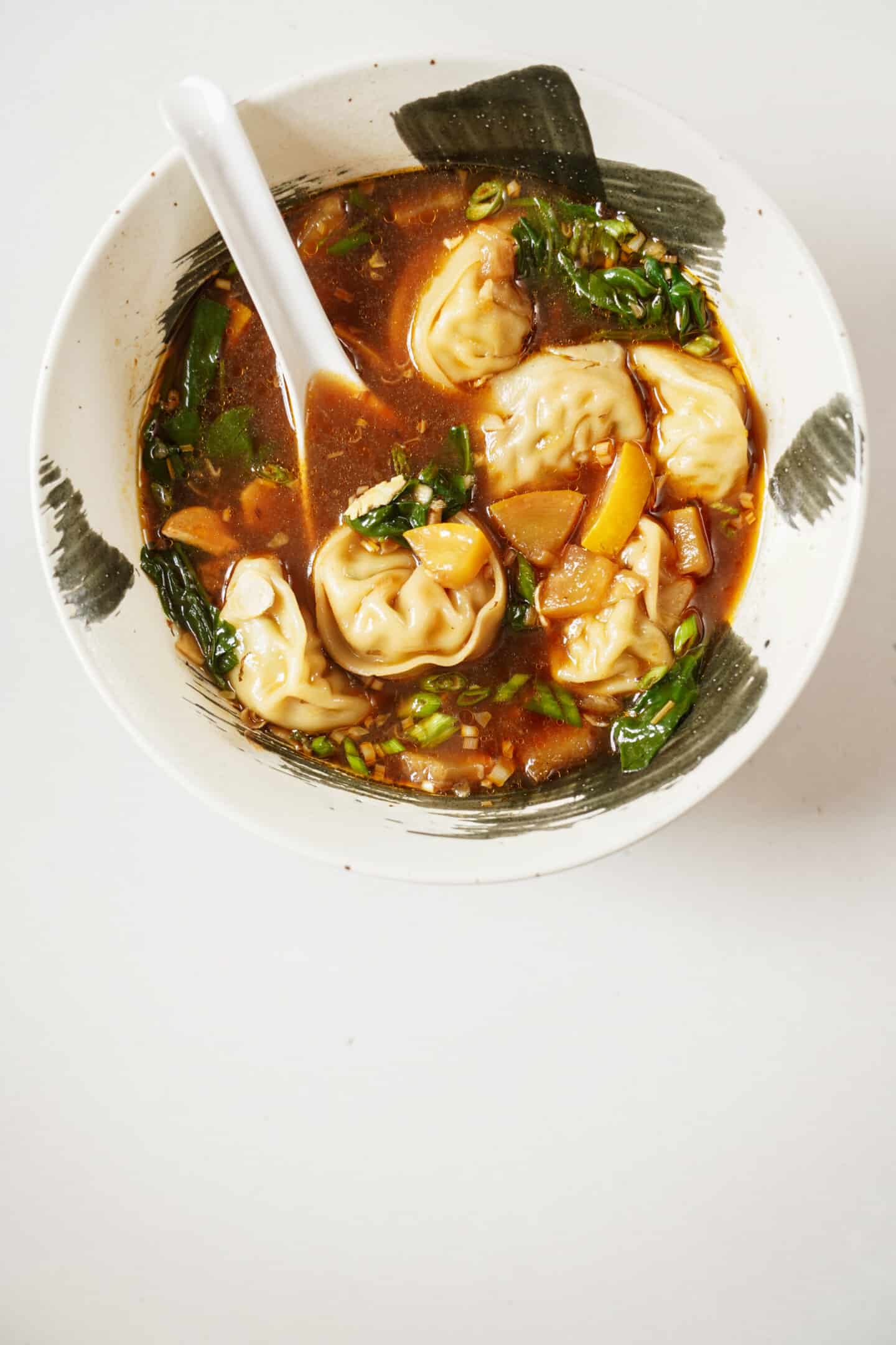 Dumpling soup in a bowl with a spoon