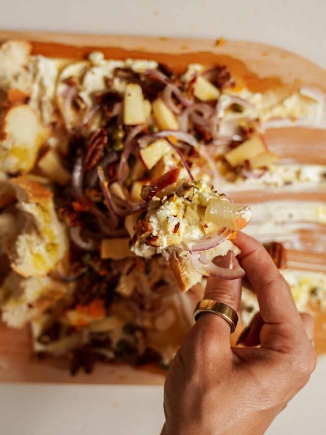 Cheese board with hand picking off toppings