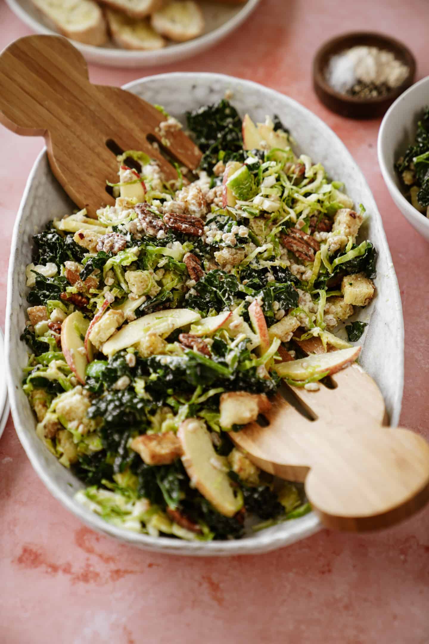 Winter chopped salad in a serving bowl with dressing recipe on top