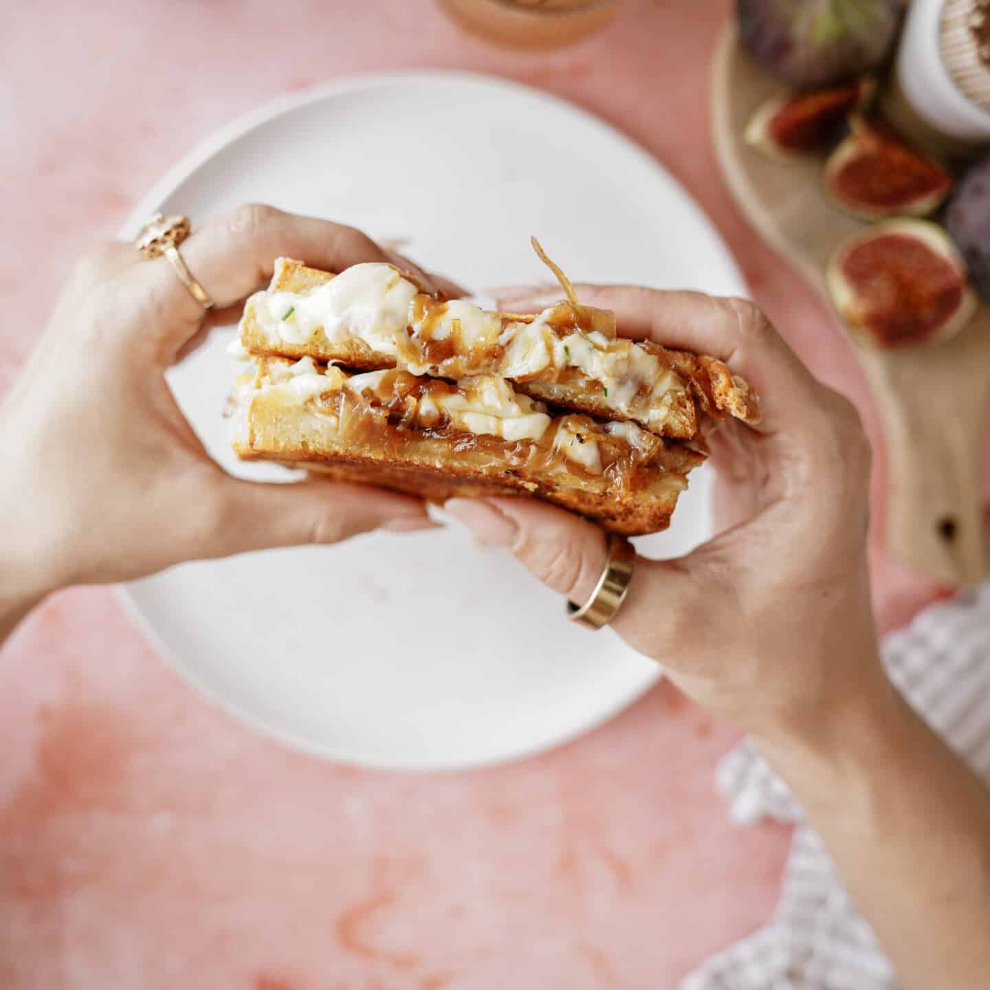 Hands holding a french onion grilled cheese