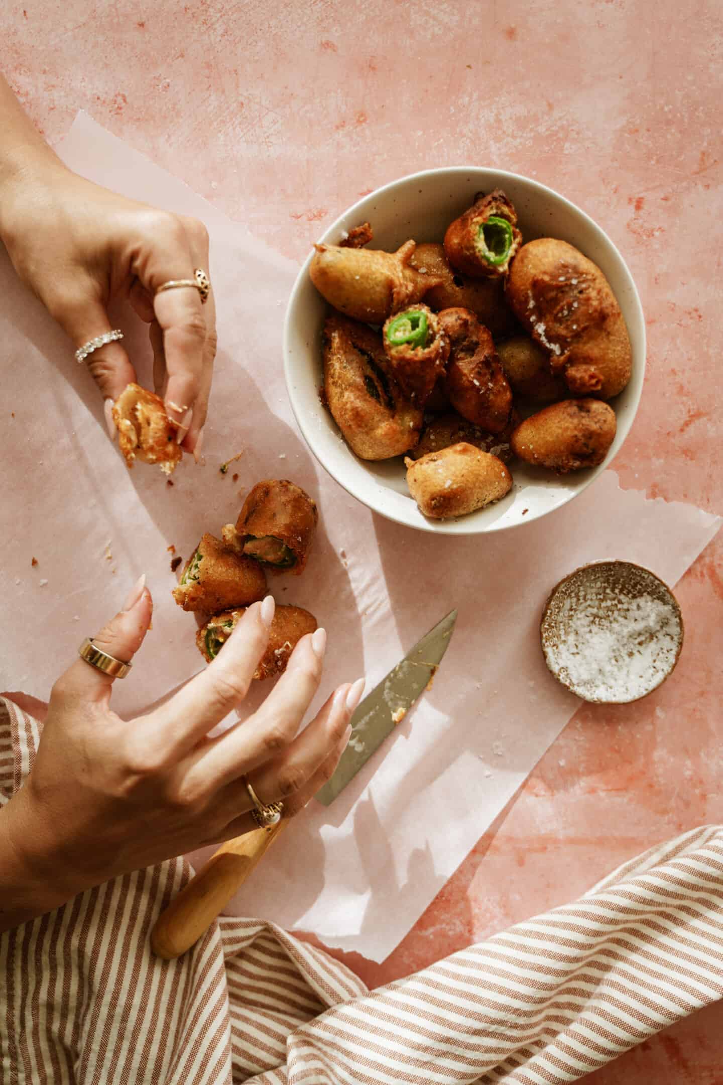 Hands eating a stuffed jalapeno popper