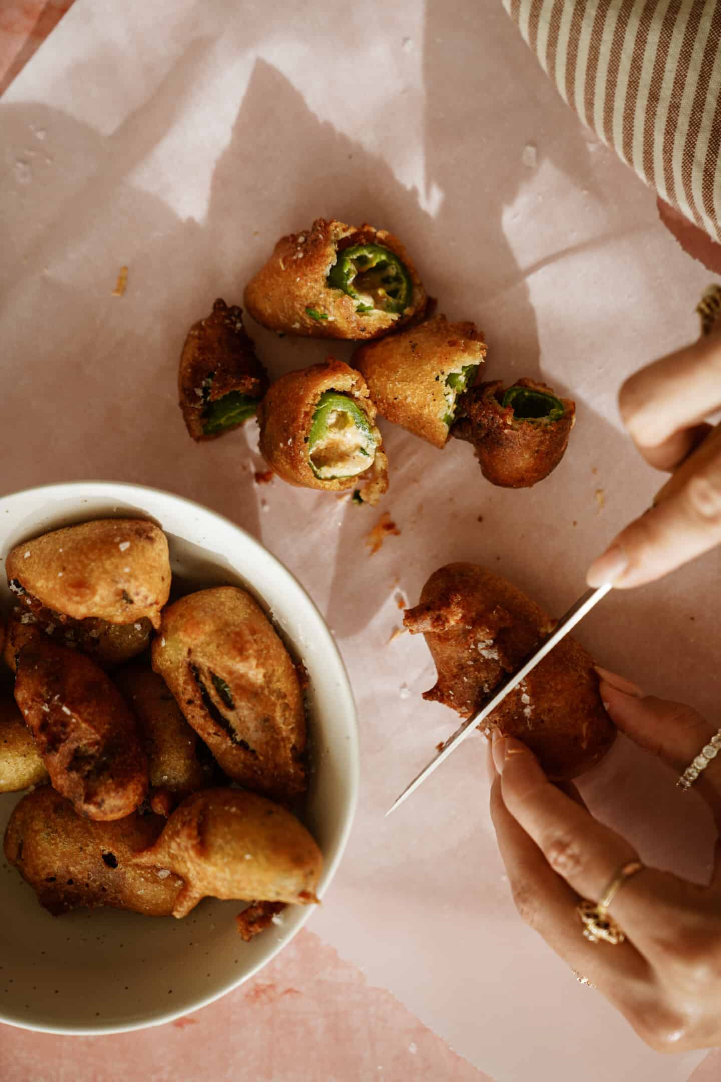 Cutting into a fried stuffed jalapeno popper