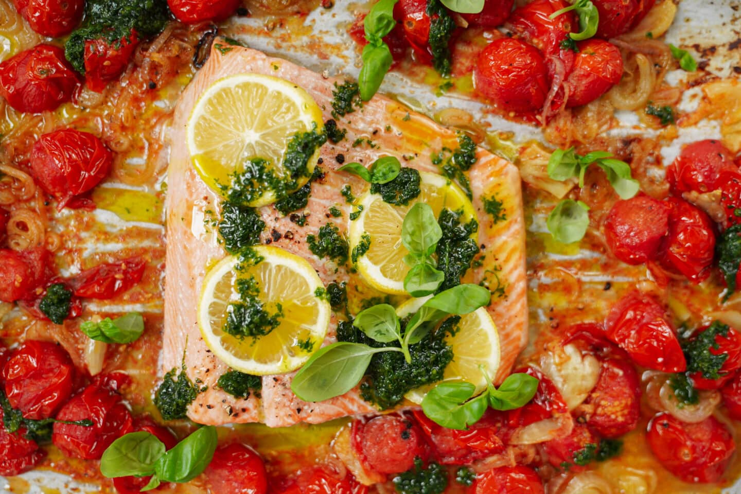 Oven baked fish surrounded by cherry tomatoes