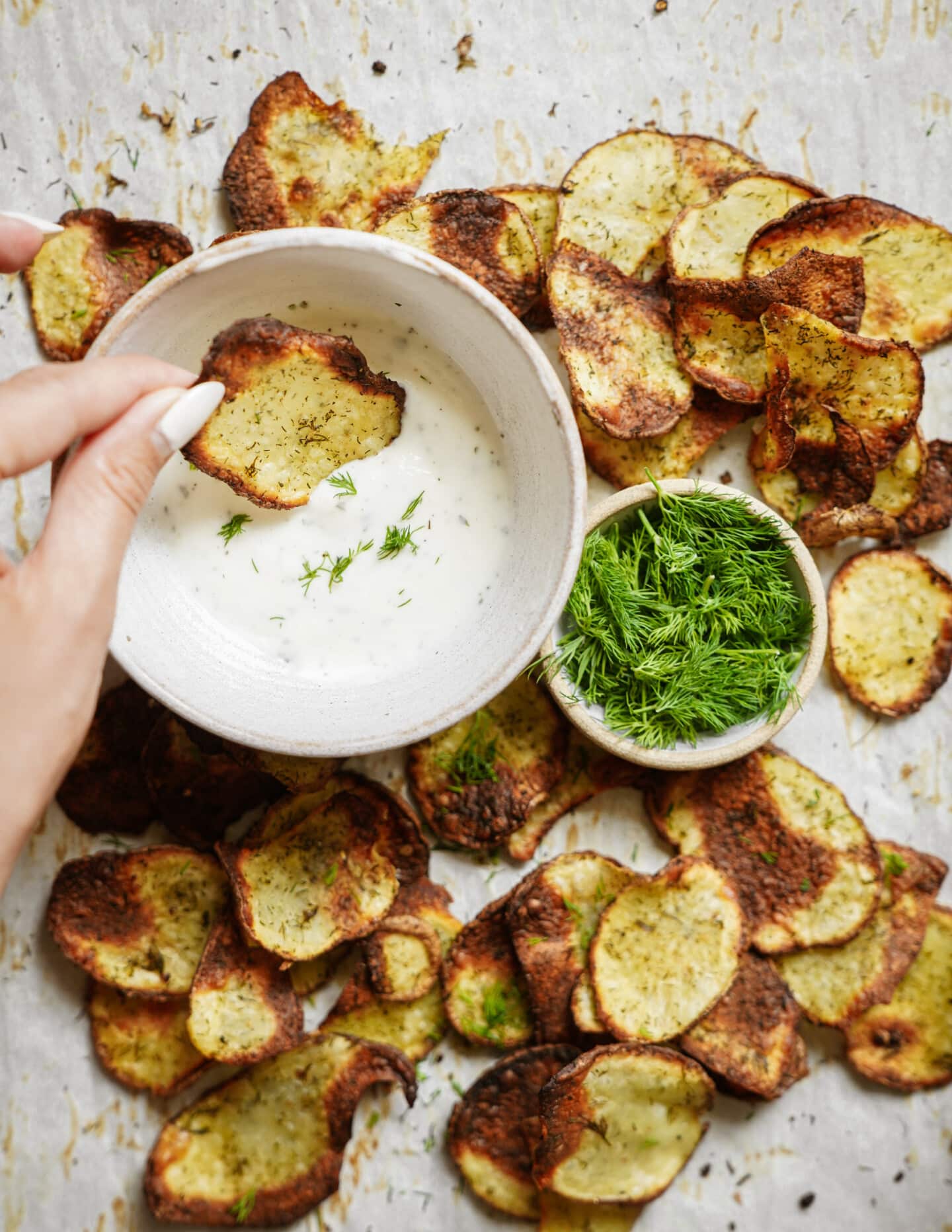 Homemade potato chips being dipped in ranch