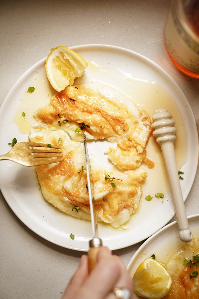 Saganaki on a serving dish with a fork and knife cutting it