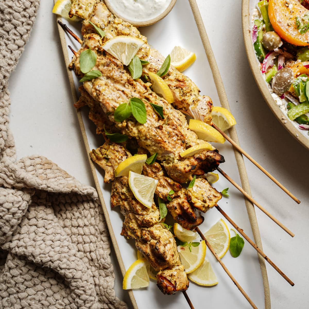 Greek chicken souvlaki on skewers on a plate