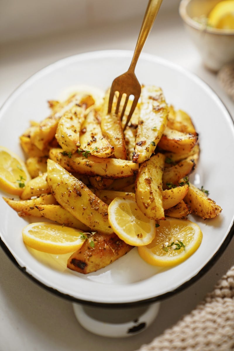 Greek Potatoes on a plate with a fork in them