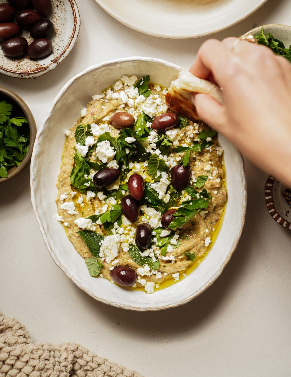 Whipped eggplant dip with a pita dipping into it