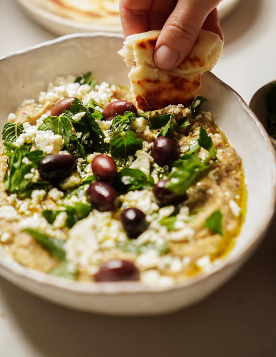 Whipped eggplant dip with a pita dipping into it