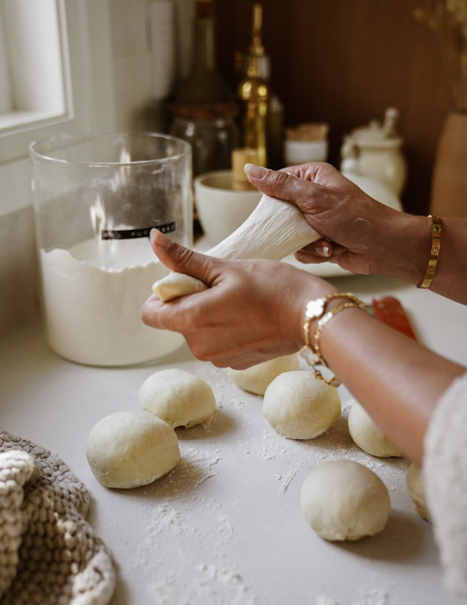 Hand stretching out pita dough