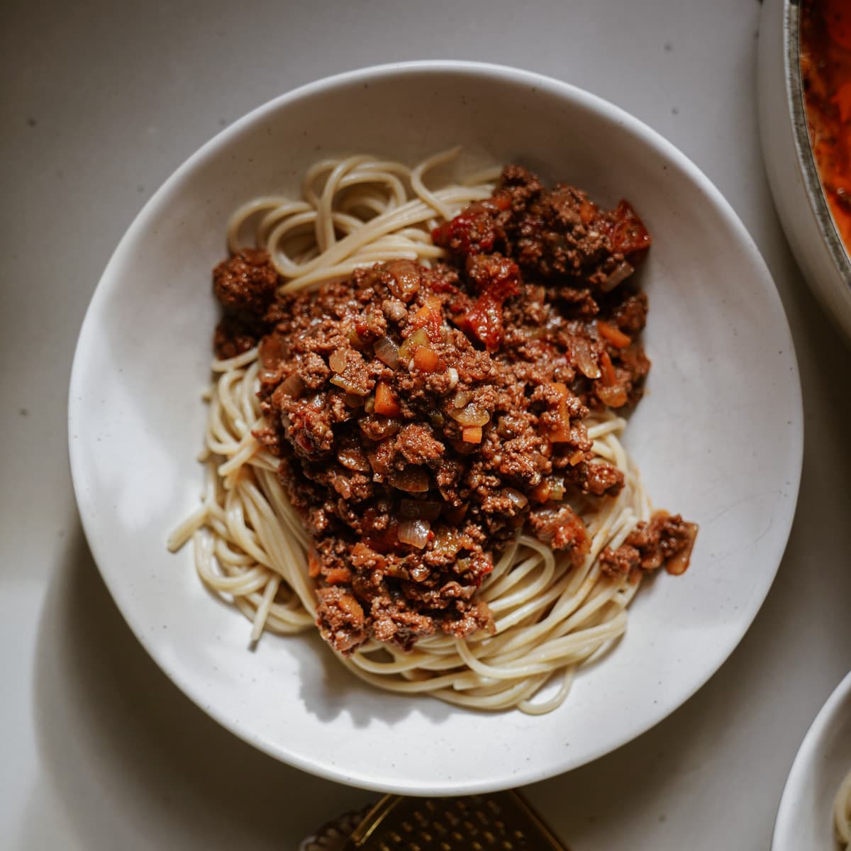 Meat sauce recipe on spaghetti in a white dish