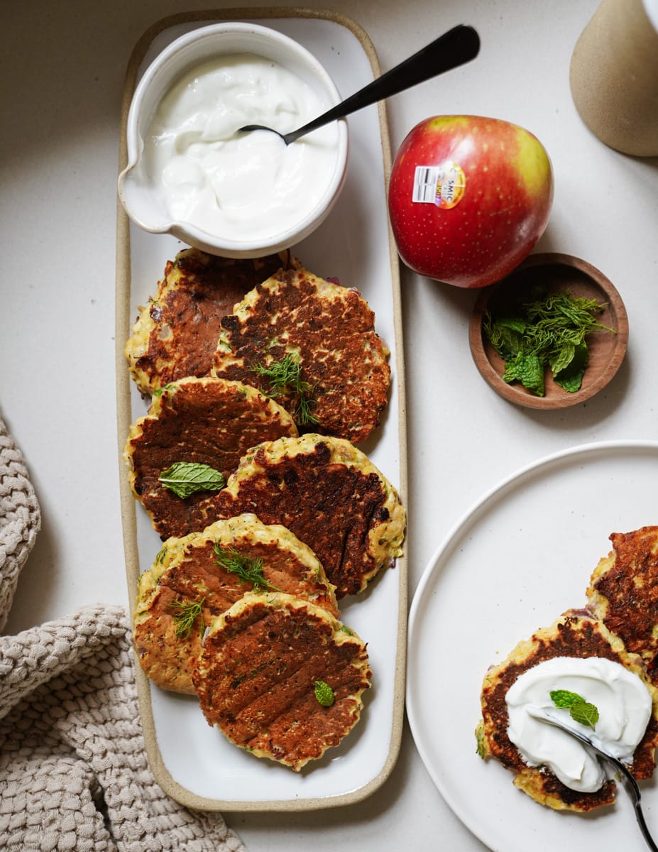 Pumpkin fritters on a serving dish with ingredients