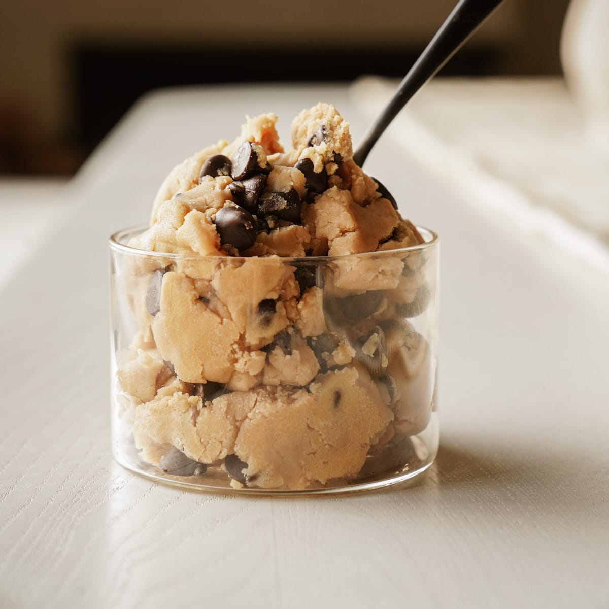 Cup of edible cookie dough with a spoon