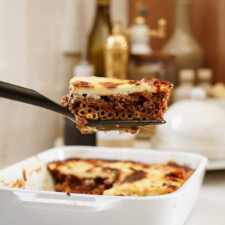Sliced piece of pastitsio coming out of a casserole dish