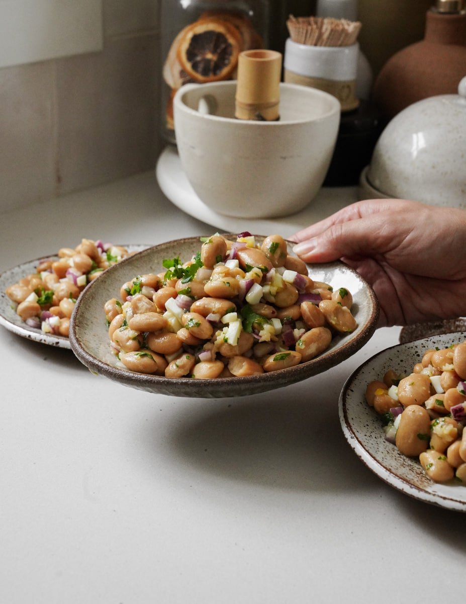 Hands serving butter beans recipe