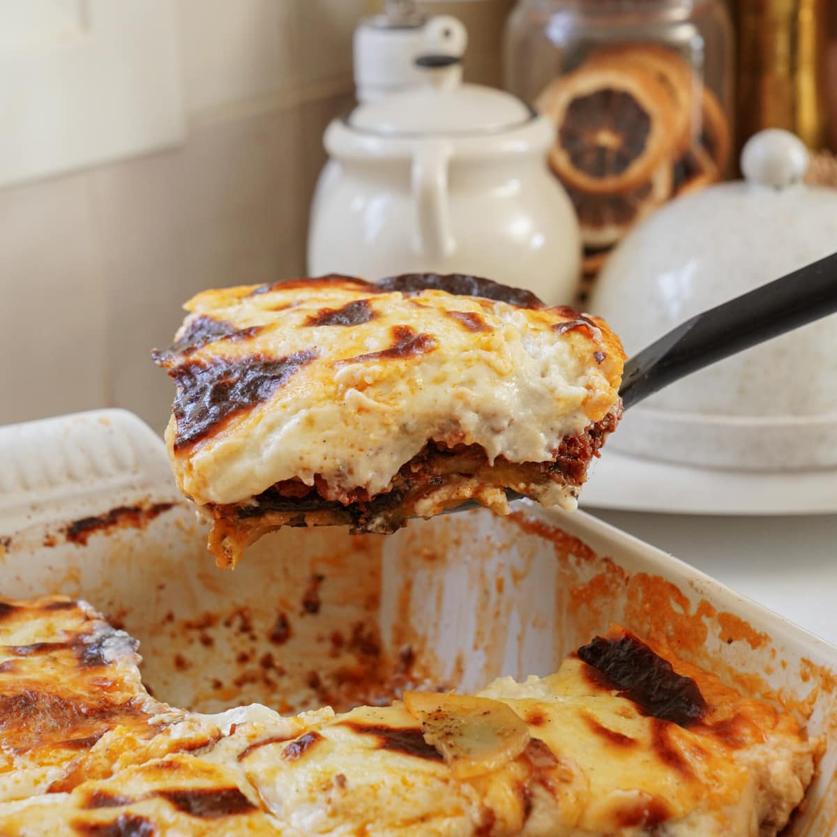 Moussaka being pulled out of a baking dish
