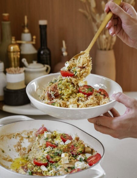 Person spooning oven baked chicken and rice into a bowl