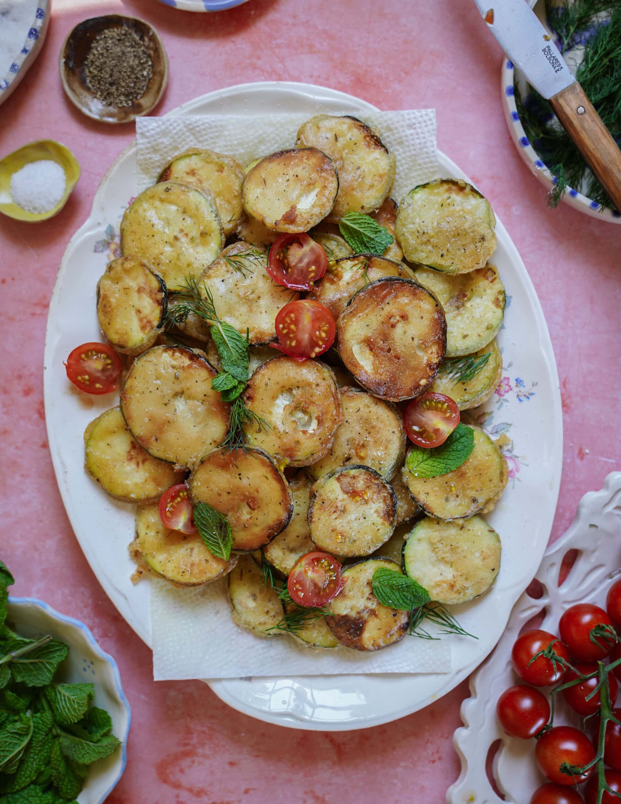 plate of fried zucchini rounds with tzatziki and fresh herbs